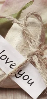 Rustic heart and twine with 'I love you' note in a romantic setting.