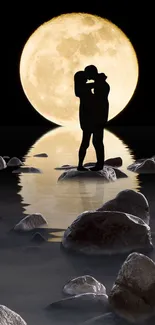 Silhouette of couple embracing under a full moon with rocky shore reflecting on water.