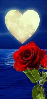 Romantic wallpaper with heart moon and red roses over ocean at night.