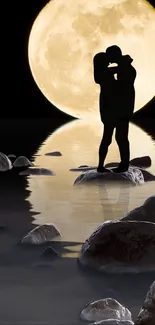 Silhouette of a couple kissing under a large full moon reflecting on water.