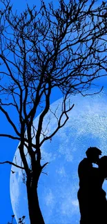 Silhouetted couple hugging by tree under a full blue moon.