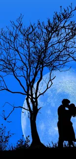 Silhouette of a couple kissing under a large blue moon with a barren tree nearby.