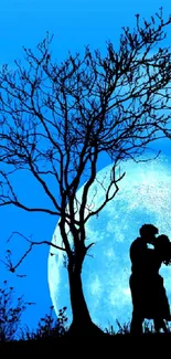 Silhouette of a couple kissing under a tree with a large moon in the background.