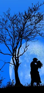 Silhouette of couple kissing under a tree against a full moon backdrop.