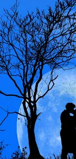 Silhouette of a couple kissing under a tree with a large moon in the background.