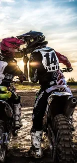 Motocross riders sharing a moment at sunset.