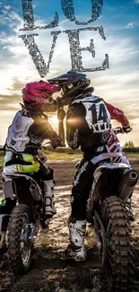 Romantic motocross couple at sunset on dirt bikes under a love sign.