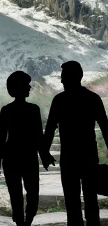 Couple silhouette with mountain backdrop.