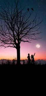 Silhouette couple under tree with a full moon and starry night sky.