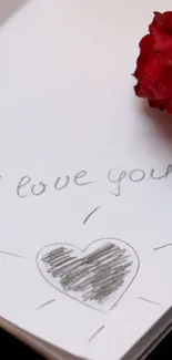 A love note and red rose on paper.