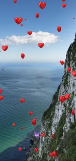 Romantic ocean view with red hearts floating over cliffs and sea.