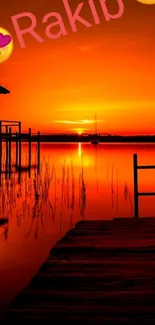 Romantic orange sunset over lake with pier and glowing sky.