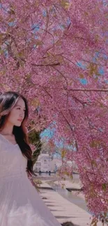 Woman under a pink blossom tree in spring.