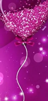 Heart-shaped pink balloon with sparkles on a magenta background.