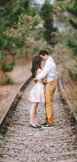 Romantic couple on railway track surrounded by nature.