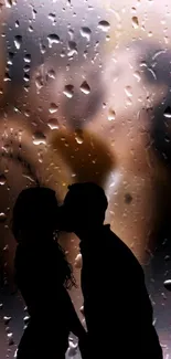 Silhouette of a couple kissing behind a rain-covered window, creating a dreamy ambiance.