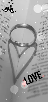 Silver ring casting heart shadow on book, expressing romance.