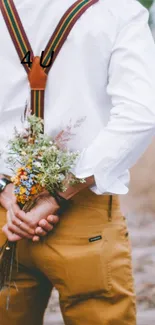 Couple on railway tracks, holding flowers with a romantic rustic backdrop.