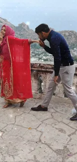 A couple in traditional attire with a scenic mountain view.