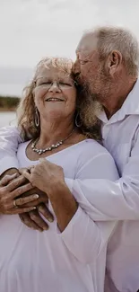 Elderly couple embracing by a serene lakeside, showcasing love.