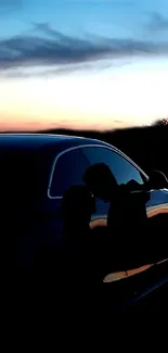 Silhouette of a couple with a sunset sky and reflective car surface in the backdrop.