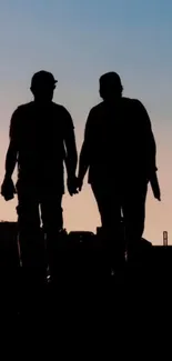 Silhouette of a couple holding hands against a sunset sky.