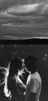 Silhouette of a couple by a lake with dramatic clouds.