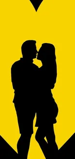 Silhouette of couple kissing with a yellow heart background.