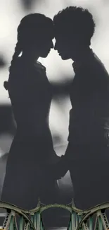 Silhouette of a couple in a romantic moment on a bridge.