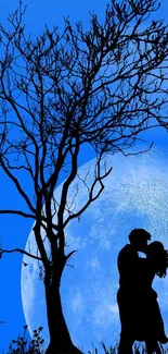 Silhouette of a couple kissing under a tree with a blue moon background.