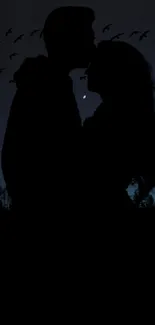 Romantic silhouette of a couple under a night sky with birds.