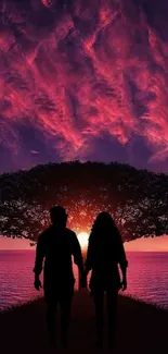 Silhouette of a couple under a vibrant sunset sky.