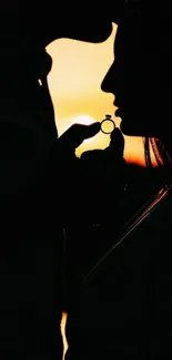 Silhouette of couple with ring against a sunset backdrop, symbolizing romance.