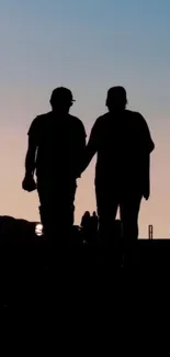 Silhouette of a couple walking at sunset.