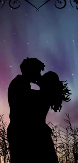 Silhouette of a couple kissing under a colorful starry sky with auroras.