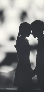 Silhouette of a couple in romantic pose against blurred background.