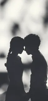 Silhouette of a couple in romantic embrace, black and white mobile wallpaper.