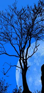 Silhouette of a couple kissing under a blue night sky with a full moon.