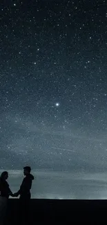 Couple holding hands under a starry night sky with a romantic silhouette.