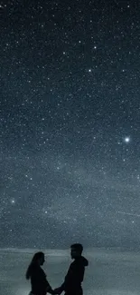 Silhouette of couple underneath a starry night sky.