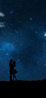 Romantic silhouette of couple under a starry night sky on a hill.