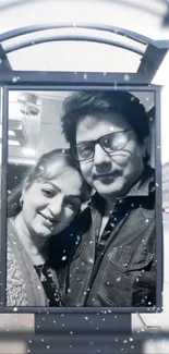 Romantic couple in black and white on city billboard with snowy backdrop.