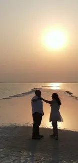 Romantic couple dancing on a beach at sunset.