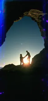 Silhouette of couple at sunset on a coastal cliff with a natural rock arch.