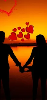 Romantic silhouette of couple by orange sunset with red hearts.