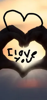 Hands forming a heart with 'I Love You' text at sunset.