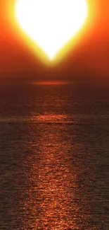 Heart-shaped sunset over ocean with orange hues, creating a romantic scene.