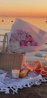 Beach picnic setup at sunset with flowers, wine, and a serene sea view.