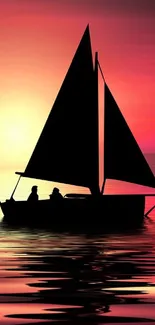 Silhouette of a sailboat at sunset with pink and orange sky.