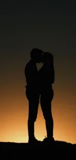 Silhouette of a couple embracing with a sunset background.